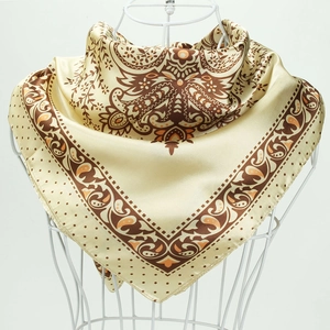 Détail macro d'un carré de soie avec motifs paisley champagne élégants et floraux