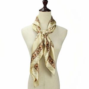 Détail du foulard en soie paisley champagne montrant la texture élégante du tissu satiné