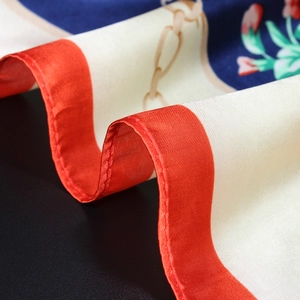 Macro shot of satin silk scarf showing floral print texture and glossy fabric folds