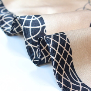 Champagne gold silk scarf with black geometric patterns and fine rolled edges