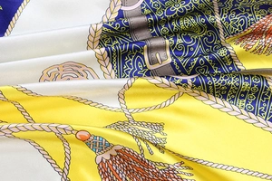 Macro shot of chain print silk scarf fabric with tassels and classic paisley patterns