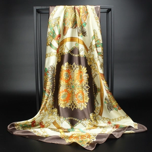 Baroque style silk scarf with golden chain print on a black metal display frame