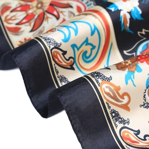 Detailed close-up of premium satin scarf featuring red floral and blue paisley patterns