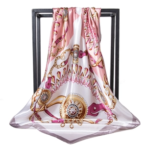 Satin silk scarf with chain print and jewelry pattern hanging on a black metal rack