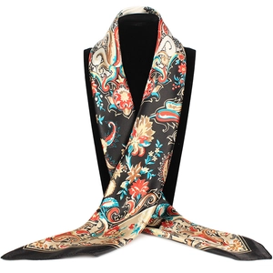 Macro shot of silk satin scarf featuring vintage paisley floral patterns on black fabric
