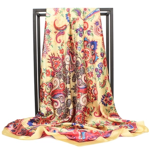 Champagne gold paisley satin square scarf with vintage floral patterns on a display stand