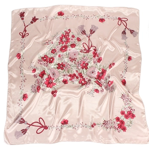 Close-up of pink floral silk scarf showing elegant flower patterns and smooth satin texture