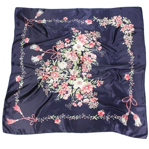 Detailed view of the dark blue silk scarf with floral prints and tassel patterns