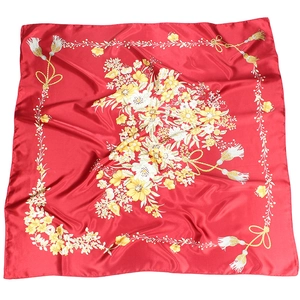 Detail of red floral silk scarf featuring yellow flower pattern and tassel border