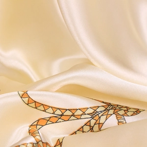 Macro shot of high-quality champagne gold silk scarf with detailed twill weave and rope pattern