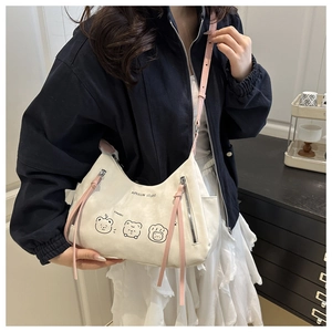 Detail of canvas tote bag with cartoon bear print and pink shoulder strap on a model