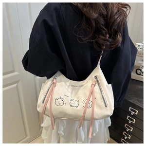 Détail du cabas blanc cassé avec oursons mignons et tirettes de zip en cuir rose stylées