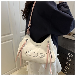 Détail du sac cabas en toile avec bandoulière en cuir rose et imprimés d'ours mignons