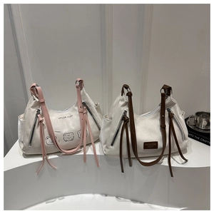 Detail of high-capacity tote bags with tassels and stylish contrasting shoulder straps