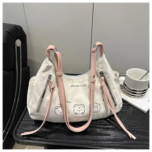 Détail d'un sac en toile blanche avec imprimé ours cartoon et anses roses