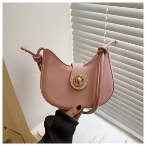 Détail du sac selle rose avec fermoir doré et bandoulière à nœud décoratif élégant