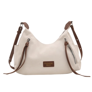 Fashionable off-white shoulder tote bag with decorative zippers and contrast leather trim