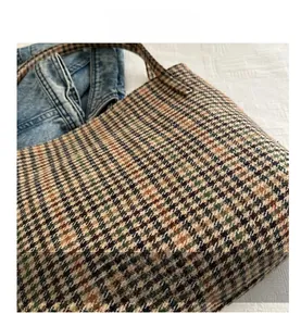 Macro view of woven houndstooth tote bag featuring rich earthy tones and detailed fabric texture