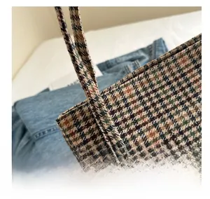 Close-up of high-quality stitching and textured plaid fabric on a stylish tote bag
