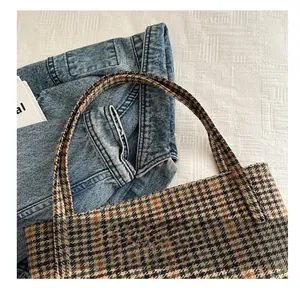 Close-up of houndstooth tote bag handle showing brown and green woven wool texture