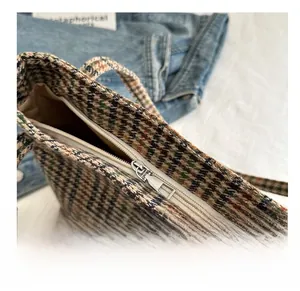 Detail shot of the smooth metal zipper and houndstooth fabric on the retro tote bag