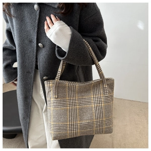 Detailaufnahme der Woll-Tote-Bag mit Hahnentrittmuster über einem grauen Mantel