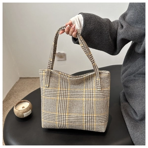Detailansicht der braun-grau karierten Webstruktur und Griffe der großen Tote Bag