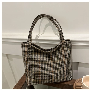 Nahaufnahme der Retro-Hahnentritt-Tasche mit braunen Griffen und Kaffeetassen-Szene