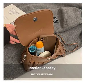 Detail view of the brown pleated bag interior showing space for phone and makeup