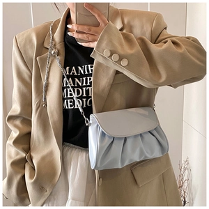 Close-up of light blue pleated cloud bag with silver metal chain on model