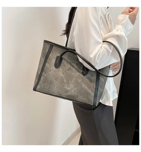 Detailed view of the large grey tote bag with washed texture and black PU leather straps