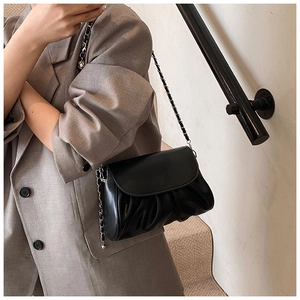 Detail showing the natural pleats and soft PU leather texture of this black flap bag