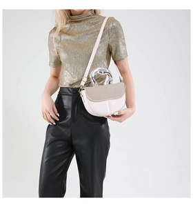 Detail der beigen Satteltasche mit Perlenstruktur und silbernem Metallgriff