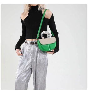 Detail der grünen Ledertasche mit beige gewebter Klappe und gewelltem Silbergriff