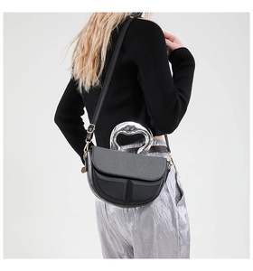 Details einer schwarzen Satteltasche mit rundem Silbergriff und geometrischer Prägung