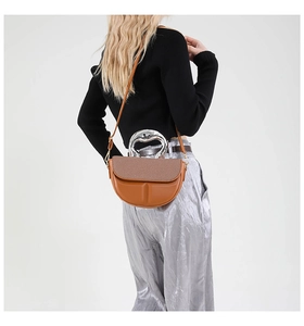 Detail der braunen Satteltasche mit großem Silbergriff und gewebter Deckelstruktur