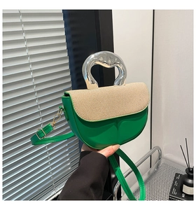 Detail der grünen Leder-Satteltasche mit beiger Klappe und silbernem Metallgriff