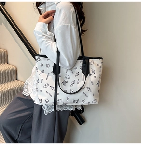 Detail of white tote bag with black minimalist illustrations and a large capacity for commute