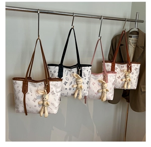 Detail of four colorful printed tote bags with cute bunny charms for daily commuting