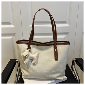 Detail of cream contrast tote bag with premium leather texture and cute puppy charm