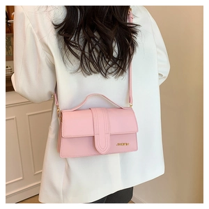 Détail du petit sac bandoulière rose clair avec logo doré et poignée supérieure