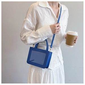 Blue minimalist transparent square bag with detachable shoulder strap shown on model