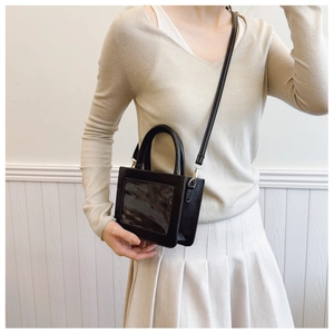 Model view of black rectangular crossbody bag with clear window and slender strap