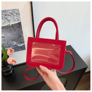Detail of red PU leather bag featuring a transparent display window and top handle