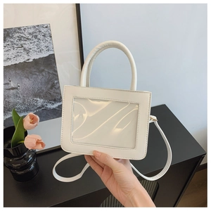 Detail of white glossy mini handbag with a transparent window and smooth top handle