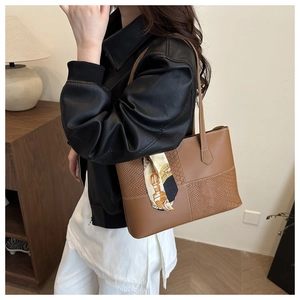 Brown leather tote bag with crocodile texture and floral scarf on a model