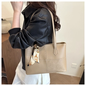 Detail of large beige tote bag featuring square snake pattern patchwork and silk scarf