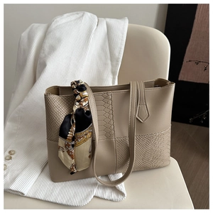 Détail d'un grand sac cabas avec texture serpent et décoration de poignée en soie