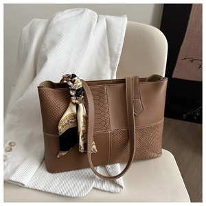 Détail d'un sac cabas marron avec textures mixtes et foulard en soie vintage décoratif