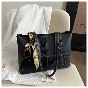 Détail d'un sac cabas noir en patchwork avec surpiq coutures blanches et foulard en soie imprimé